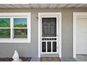 Inviting front entry features a secure screen door, a nearby window, and a charming angel statue at 900 Maple Ave, Fruitland Park, FL 34731