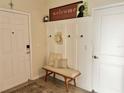 Welcoming entryway featuring a built-in hall tree with bench seating and decor at 916 Carmillion Ct, Groveland, FL 34736