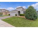 Charming home featuring a paver driveway, attached garage, and well-maintained landscaping at 916 Carmillion Ct, Groveland, FL 34736