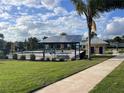 Community pool area featuring solar panel roof, landscaping, and sidewalk at 987 Fiesta Key Cir, Lady Lake, FL 32159