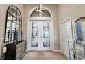 Welcoming foyer with decorative mirrors, a striking light fixture, and glass-paneled double doors at 10199 Mainsail Dr, Oxford, FL 34484