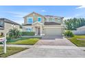 Charming two-story home with a well-manicured lawn and a brick paved driveway at 10219 Lenox St, Clermont, FL 34711