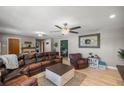 Comfortable living room featuring a leather sectional, ceiling fan, and neutral paint at 1107 Valley Rd, Fruitland Park, FL 34731