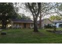 Inviting single-story home with a covered porch, mature trees, and a well-manicured lawn at 11312 Haskell Dr, Clermont, FL 34711