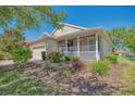 Charming single-story home featuring a cozy front porch and beautiful landscaping at 117 Falling Acorn Ave, Groveland, FL 34736
