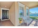 Inviting front porch with a comfortable wicker seating area and black front door at 117 Falling Acorn Ave, Groveland, FL 34736