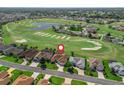 Aerial view of house on golf course featuring lush landscaping, a neutral color palette, and a red map pin at 12136 Se 176Th Loop, Summerfield, FL 34491