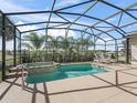 Relaxing screened pool with a jacuzzi, lounge furniture, and views of the golf course at 12136 Se 176Th Loop, Summerfield, FL 34491