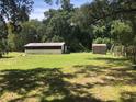 Spacious backyard with green grass and sheds, offering plenty of room for outdoor activities at 136 S Commercial St, Coleman, FL 33521