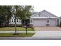 Beautifully landscaped single Gathering home with brick paver driveway and three car garage at 142 Bayou Bend Rd, Groveland, FL 34736