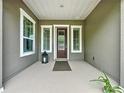 Inviting front porch with decorative front door, stylish windows, and a charming lantern at 142 Bayou Bend Rd, Groveland, FL 34736