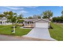 Inviting single-story home featuring a well-kept lawn and a spacious two-car garage at 17965 Se 107Th Ct, Summerfield, FL 34491
