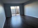 Bedroom with dark hardwood floors, gray walls, and sliding doors that lead to a private brick patio at 1928 Conway Rd # 23, Orlando, FL 32812