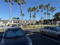 Community exterior shot of apartments with palm trees, parking lot, and neighboring cars at 1928 Conway Rd # 23, Orlando, FL 32812