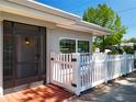 Inviting home exterior featuring a screened entry, white picket fence, and brick-lined walkway at 193 Bay Rd, Mount Dora, FL 32757