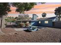 A private backyard with a picnic table, screen porch, mature trees, and a lush sunset at 219 N Rossiter St, Mount Dora, FL 32757