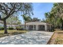 Well-maintained single-story home with covered carport and spacious driveway, surrounded by mature landscaping at 234 S Central Ave, Apopka, FL 32703