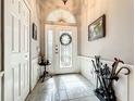 Elegant foyer with tile flooring, wainscoting, and decorative front door with glass detailing at 24112 Robinwood St, Leesburg, FL 34748