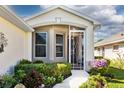 Inviting front porch with decorative plants and view of the front door at 27121 Greenfly Orchid Ln, Leesburg, FL 34748