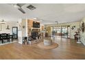 Spacious living room with brick fireplace, wood floors, and sliding glass doors at 28416 Tammi Dr, Tavares, FL 32778