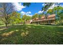 Expansive front lawn and beautiful home surrounded by lush greenery and mature trees on a sunny day at 39636 Carolina Ave, Lady Lake, FL 32159
