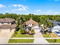 Aerial view of a home showing its beautiful landscaping, manicured lawn and proximity to mature trees at 4419 Azure Isle Way, Kissimmee, FL 34744