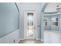 Light and airy foyer featuring decorative tile flooring, fresh blue walls and leaded glass in the front door at 4419 Azure Isle Way, Kissimmee, FL 34744