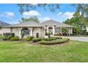 Well-maintained home featuring a manicured lawn, symmetrical landscaping, and a welcoming front entrance at 6106 Spinnaker Loop, Lady Lake, FL 32159