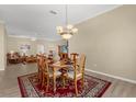 Cozy dining room area with a wooden table, chandelier, and a view of the living room at 733 Palma Dr, The Villages, FL 32159