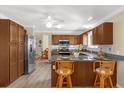 Well-lit kitchen with granite countertops, stainless steel appliances, wood cabinets, and bar seating at 733 Palma Dr, The Villages, FL 32159