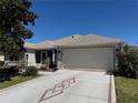 Charming single Gathering home featuring a large driveway, a two-car garage, and manicured landscaping at 737 Caldwell Ct, The Villages, FL 32162