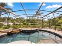 Beautiful screened-in pool area with a waterfall feature and brick paver decking at 7636 Lake Angelina Dr, Mount Dora, FL 32757