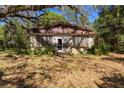 Charming stone cottage exterior featuring a vintage design and lush greenery at 801 Kilgore St, Wildwood, FL 34785