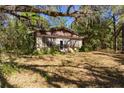 Exterior view of a stone cottage with mature landscaping and vintage charm at 801 Kilgore St, Wildwood, FL 34785