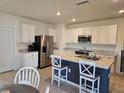 Bright kitchen featuring white cabinetry, stainless steel appliances, and granite countertops on a large island at 808 Brooklet Dr, Davenport, FL 33837