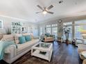 Bright and spacious living room with a ceiling fan and large windows, offering plenty of natural light at 1116 Elkhart Cir, Tavares, FL 32778