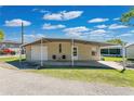 This exterior features a carport and a small seating area in front of the manufactured home at 1405 Westland Dr, Tavares, FL 32778