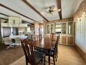 Dining room featuring exposed beams, wood paneling, and a built-in hutch for storage at 141 Hibiscus Way, Leesburg, FL 34748