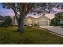 Beautiful exterior view of a home with a landscaped front yard at twilight at 17089 Se 79Th Clearview Ave, The Villages, FL 32162