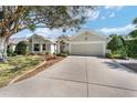 Inviting single-story home with a wide driveway and lush landscaping at 17089 Se 79Th Clearview Ave, The Villages, FL 32162