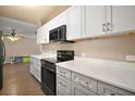 Modern kitchen featuring white cabinets, marble countertops, and stainless steel appliances at 208 Palm Way, Tavares, FL 32778