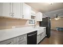 Bright kitchen featuring white cabinets, granite countertops, stainless steel appliances, and farm sink at 208 Palm Way, Tavares, FL 32778