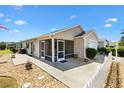 Back of the home featuring a screened in lanai, white picket fence and a walkway at 2224 Mangrove Ln, The Villages, FL 32162