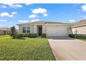 Well-manicured front lawn leading to a two-car garage and cozy facade at 2897 Sunridge Loop, St Cloud, FL 34771