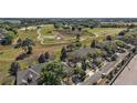 Aerial view of a neighborhood with a golf course in the background at 34448 Tuscany Ave, Sorrento, FL 32776