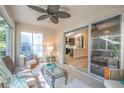 Bright sunroom features tile flooring, a ceiling fan, and sliding glass doors to the lanai at 3603 Eversholt St, Clermont, FL 34711