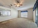 Spacious living room featuring neutral carpet, vaulted ceiling and a ceiling fan at 3827 Westerham Dr, Clermont, FL 34711