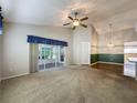 Bright and open living room area with sliding glass doors leading to a sunroom at 3827 Westerham Dr, Clermont, FL 34711