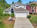 Two-story home featuring a two-car garage, well-kept lawn, and neatly trimmed bushes at 4703 Golden Beach Ct, Kissimmee, FL 34746