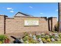 A stone community sign that reads 'Tupelo Villas' surrounded by colorful flowers and greenery at 5829 Tupelo Ter, The Villages, FL 32163